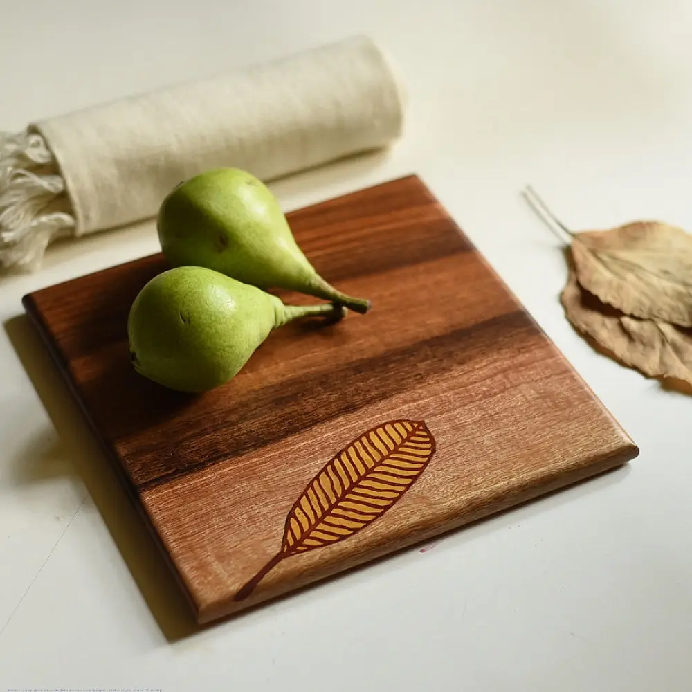 handmade wooden trivet with engraved leaf motif and two-tone finish