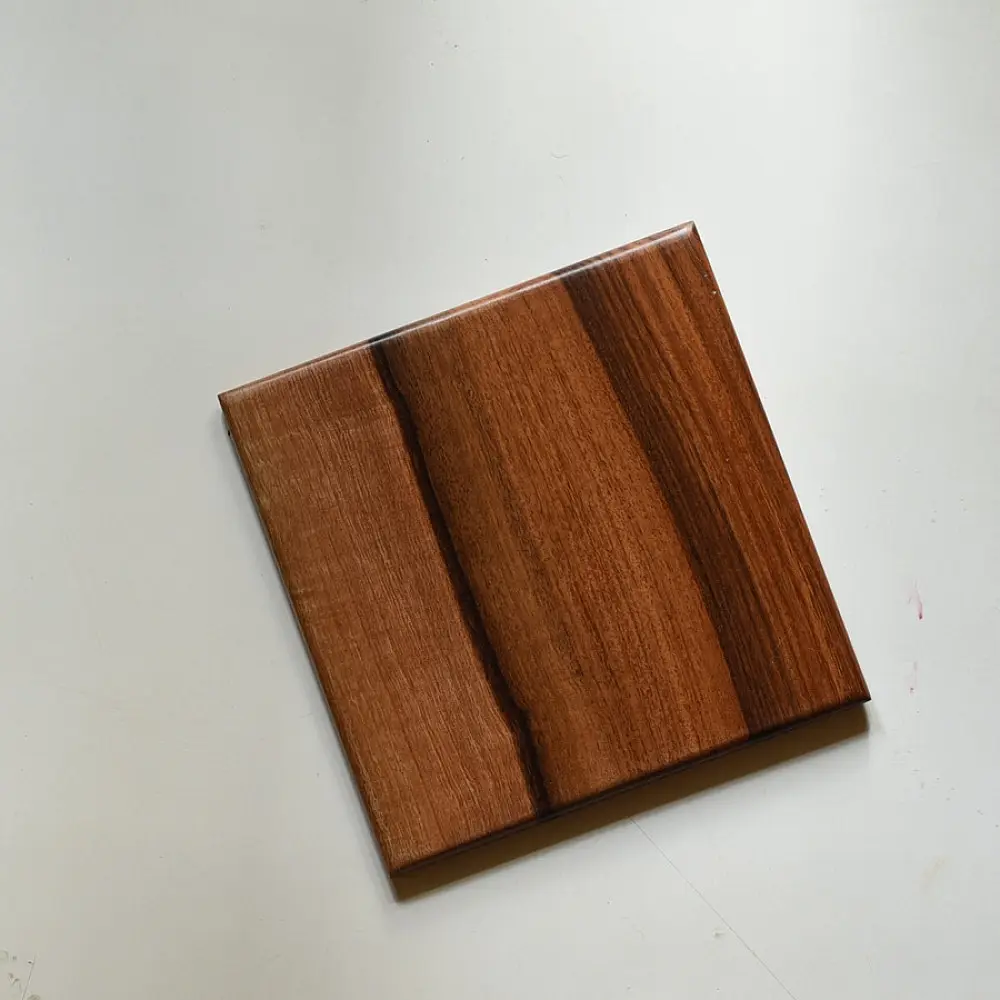 handmade wooden trivet with engraved leaf motif and two-tone finish