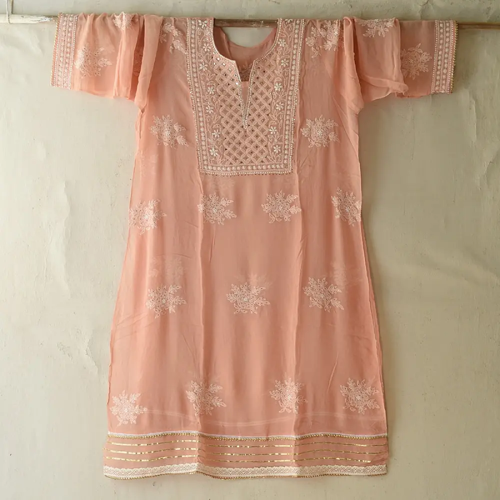 semi stitched viscose georgette kurti in delicate peach color featuring fine hand embroidered chikankari lattice yoke and all over floral motifs paired with a mukaish and lace detailed dupatta