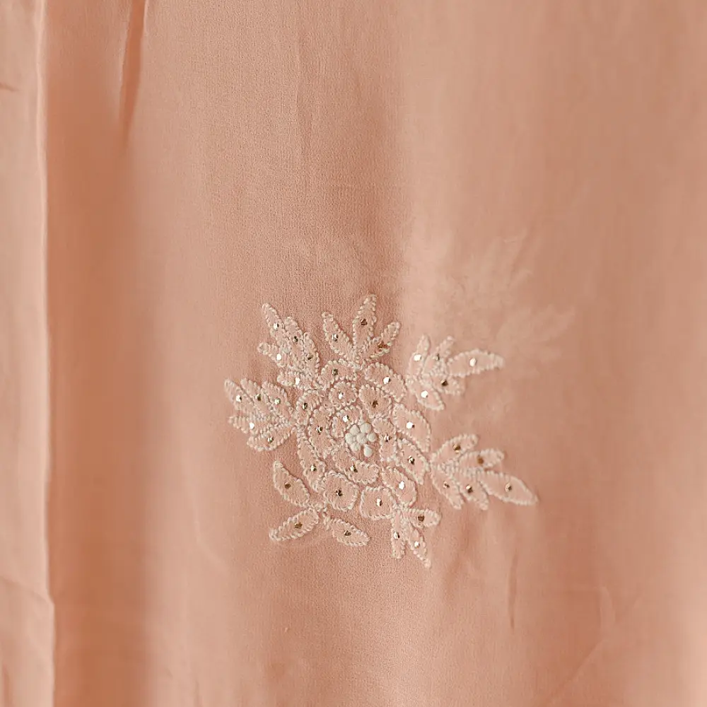 semi stitched viscose georgette kurti in delicate peach color featuring fine hand embroidered chikankari lattice yoke and all over floral motifs paired with a mukaish and lace detailed dupatta