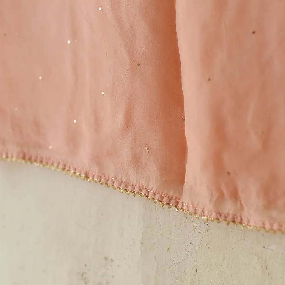 semi stitched viscose georgette kurti in delicate peach color featuring fine hand embroidered chikankari lattice yoke and all over floral motifs paired with a mukaish and lace detailed dupatta
