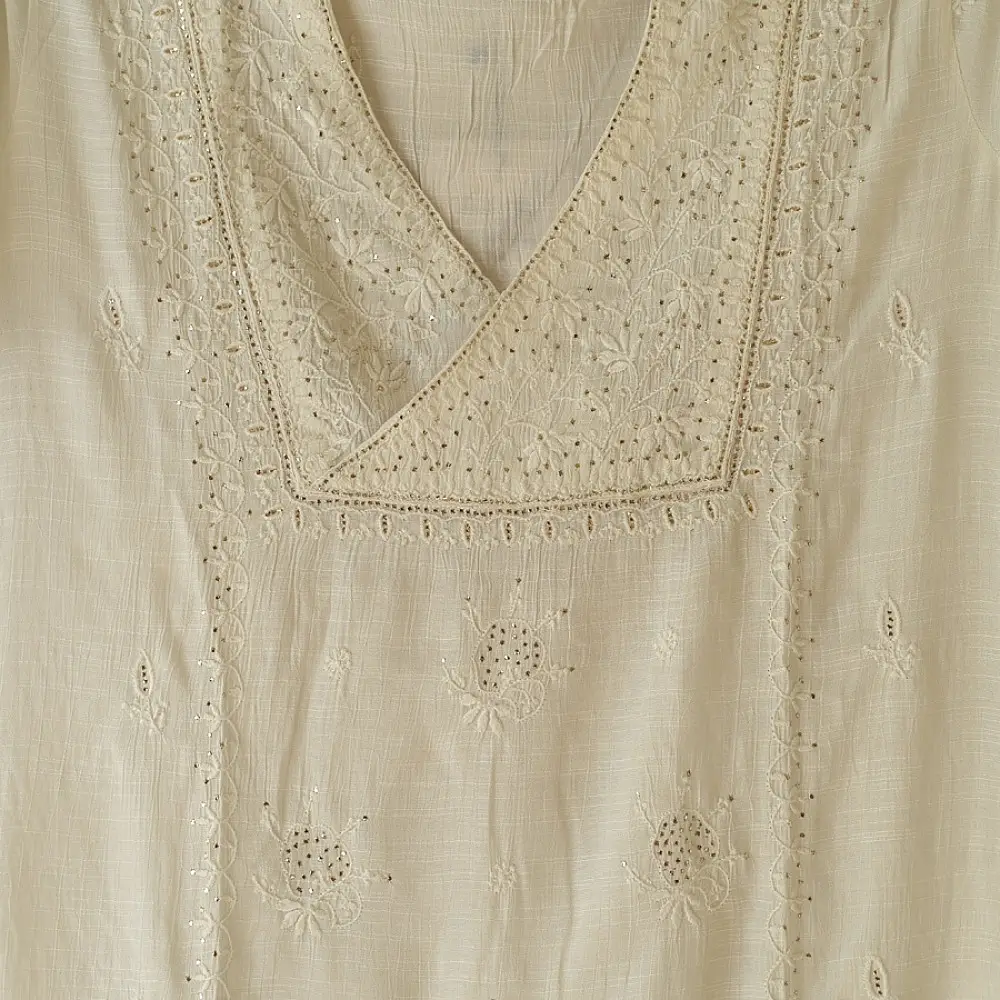 semi stitched viscose slub kurti with elegant embroidery panel design and dupatta with mukaish highlights in ethereal ivory color