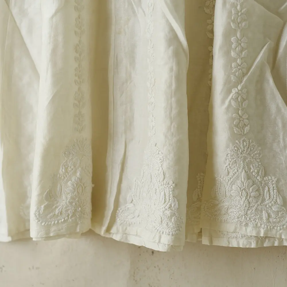 semi stitched pure silk chanderi kurti in off white with intricate hand embroidered resham chikankari and metallic gold brocade yoke and sleeve cuff details