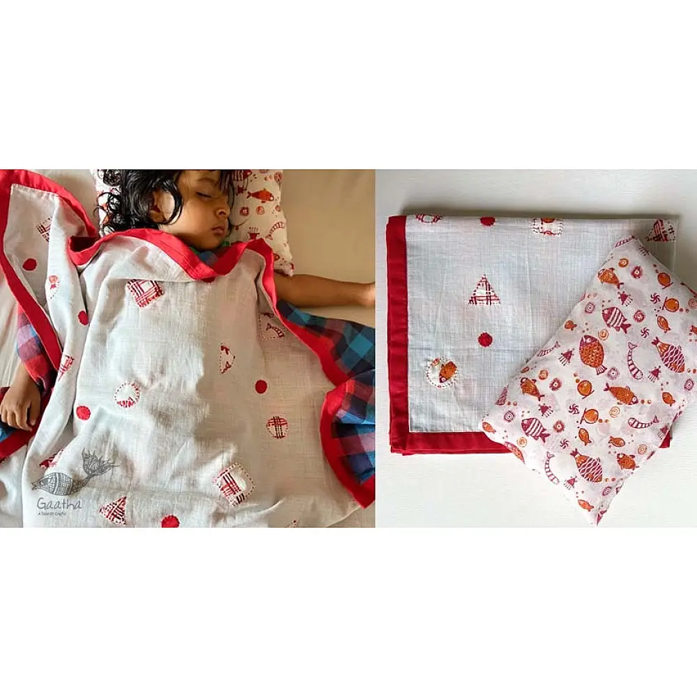 organic cotton kids bedding gift set featuring a cream fish print dohar blanket and a matching koi fish kapok pillow