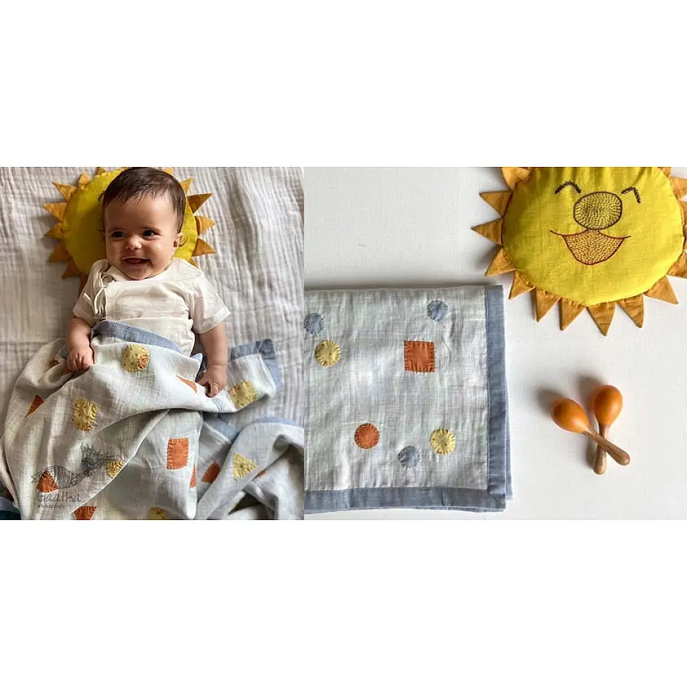 organic cotton kids bedding gift set featuring a cream block printed dhruvtara star dohar blanket sun shaped mustard seed pillow and wooden maracas
