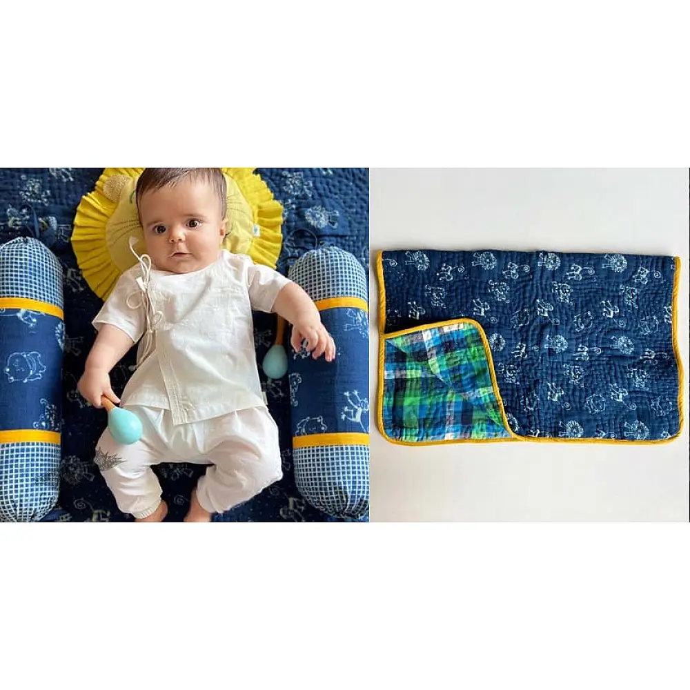 organic cotton newborn luxury bedding gift set in indigo blue zoo print featuring a soft dohar blanket round ruffle pillow matching bolsters and wooden maracas
