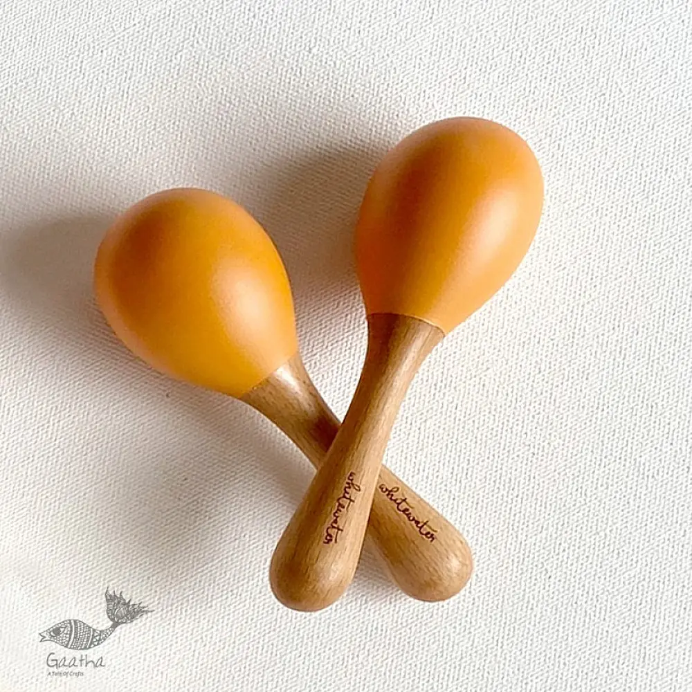 organic cotton kids gift set featuring a mustard yellow raidana micro print kapok pillow and wooden maracas shakers