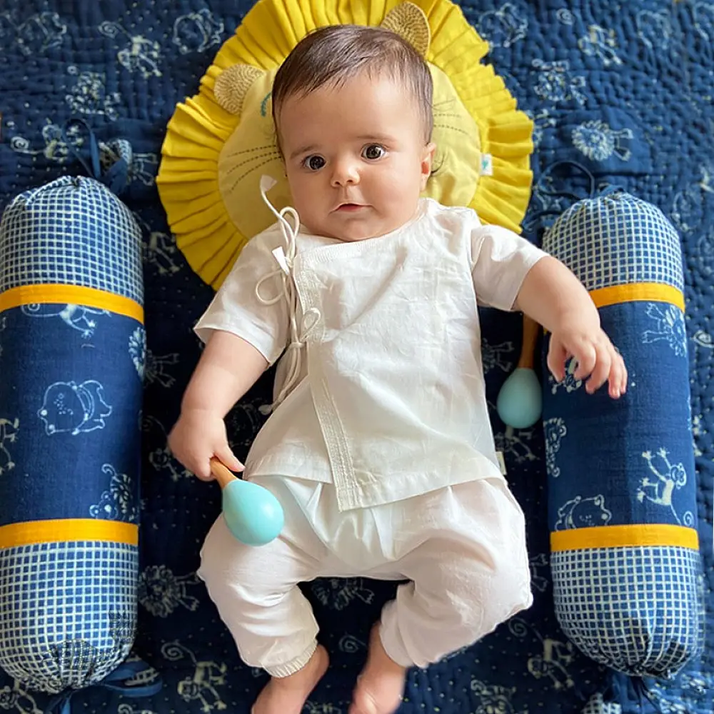 organic cotton newborn luxury bedding gift set in indigo blue zoo print featuring a soft dohar blanket round ruffle pillow matching bolsters and wooden maracas