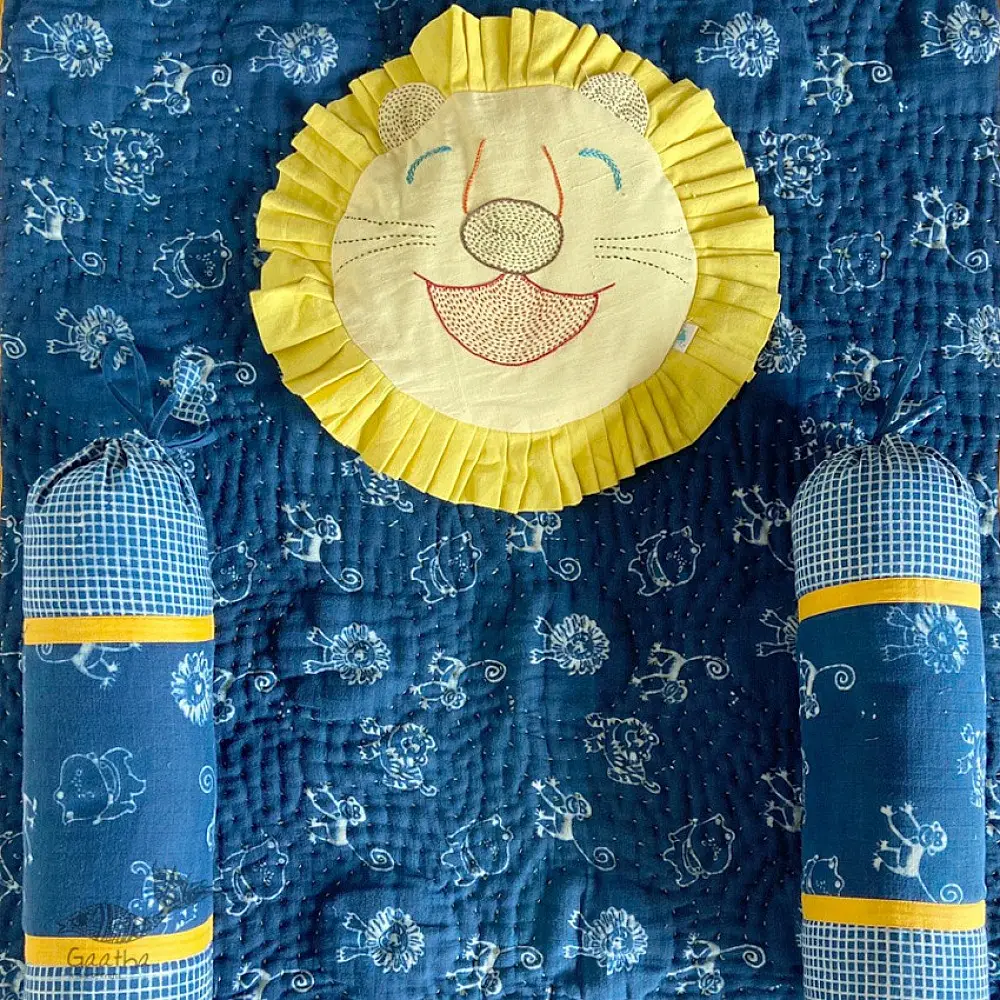 organic cotton newborn luxury bedding gift set in indigo blue zoo print featuring a soft dohar blanket round ruffle pillow matching bolsters and wooden maracas